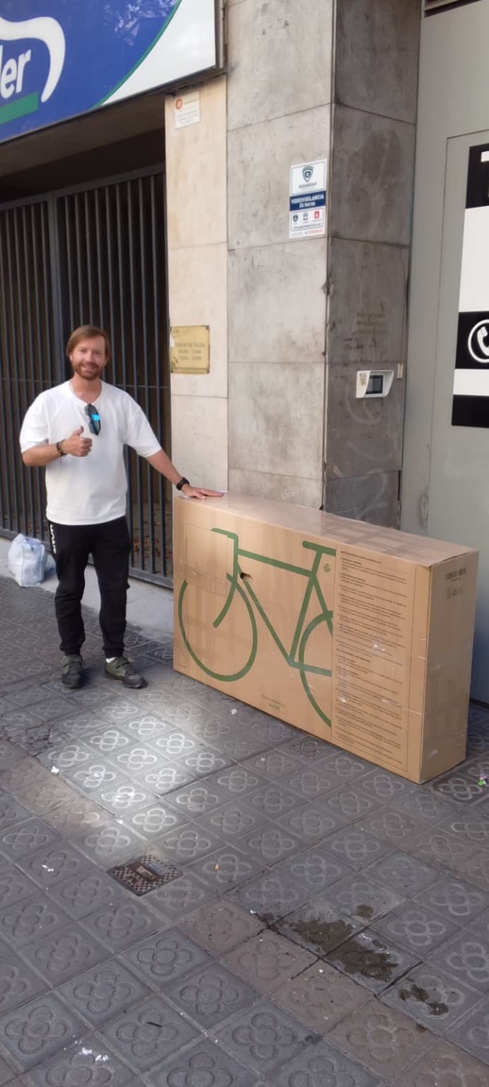 Sandro Flükiger beside his packed cardboard bike box in Barcelona